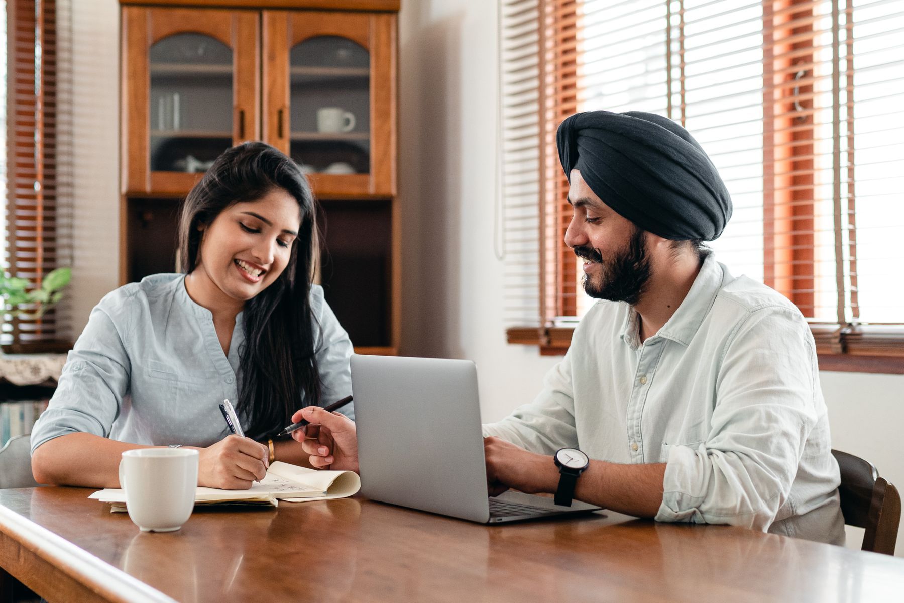 Two colleagues collaborating on a product at a laptop in a bright office