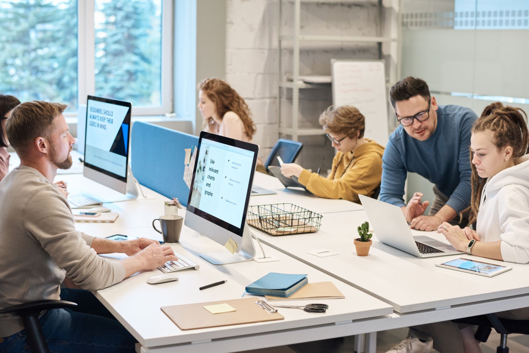 A bright, modern open-plan office with people working at desks