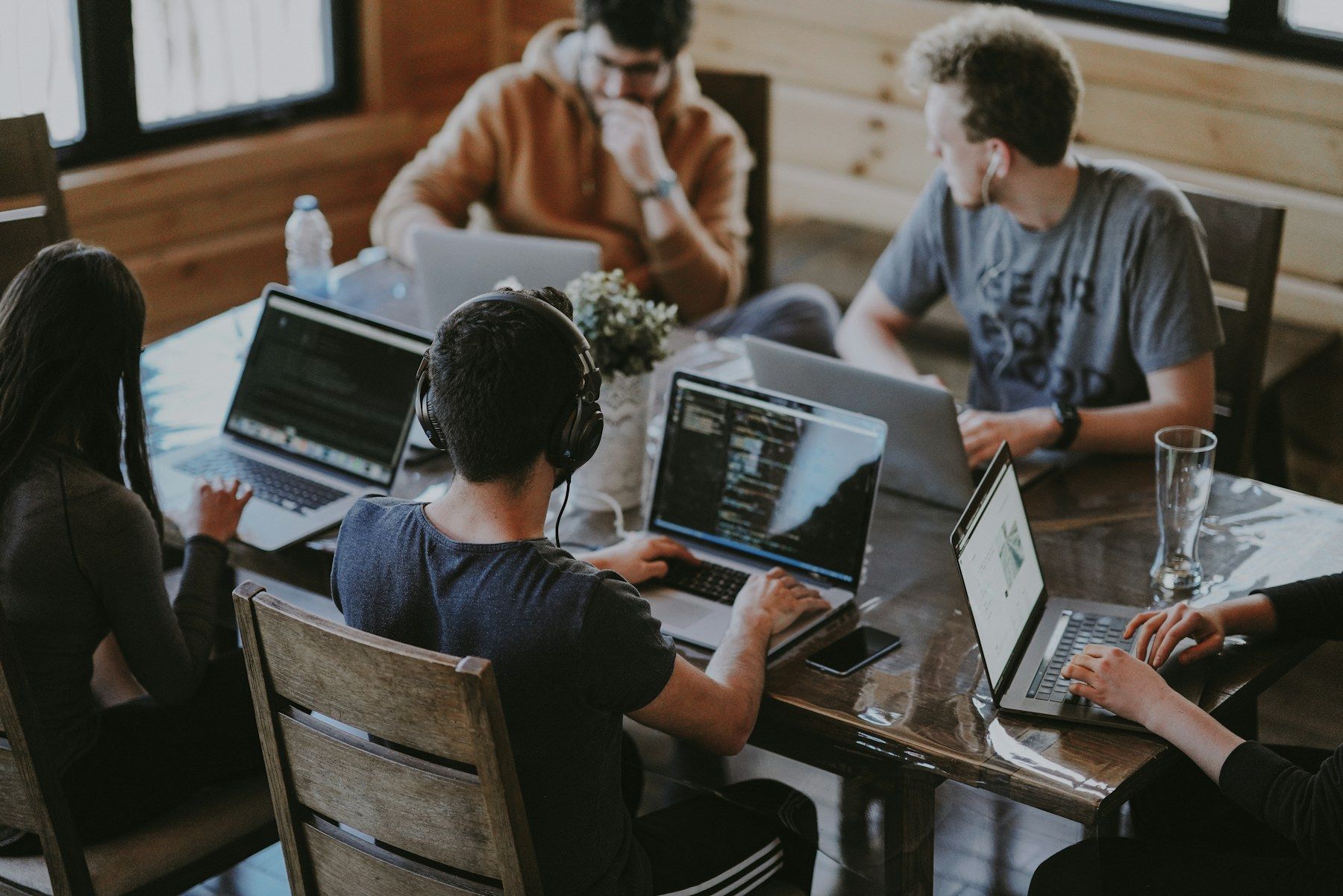 Developers working together on laptops around a shared table