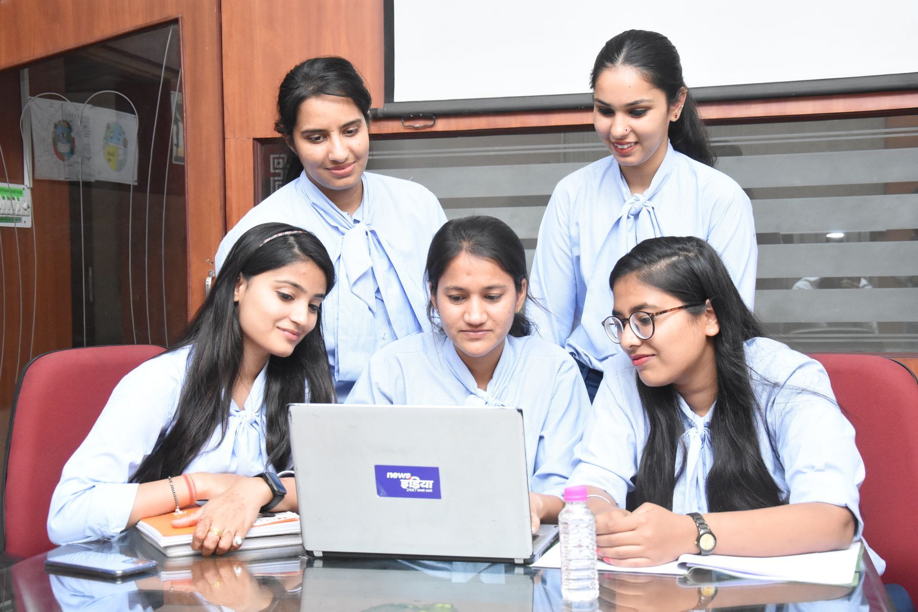 A team of young professionals reviewing work together on a laptop